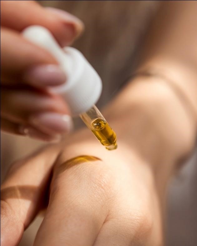 A person applying Hemp Shop oil to their arm